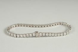 A SUPERB 14K WHITE GOLD TENNIS BRACELET set with 49 round full cut brilliant diamonds. Total