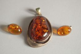 AN AMBER PENDANT AND A PAIR OF EARRINGS.