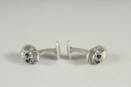 A PAIR OF HALLMARKED SILVER SKULL CUFF LINKS.