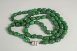 A LONG CARVED JADE NECKLACE with white gold clasp. 38ins long.