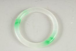 A TWO TONE JADE BANGLE. 3ins diameter.