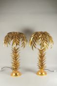 A PAIR OF GILT DECORATED PALM TREE TABLE LAMPS. 2ft 6ins high.