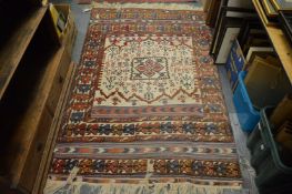 A Kilim style woven rug, cream ground with stylised motifs 185cm x 122cm.