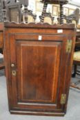 A small oak hanging corner cupboard.