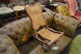 An Edwardian mahogany folding chair with cane work back panel and seats.