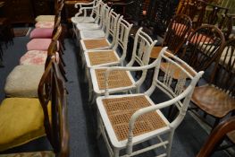 A matched set of seven white painted spindle back faux bamboo dining chairs, two with arms.