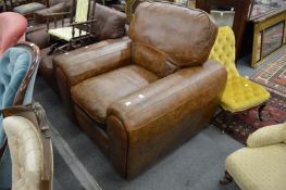 A brown leather upholstered armchair.