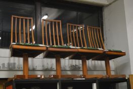 A set of four stylish teak dining chairs.