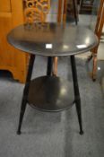 in the manor of Godwin, An ebonised two tier circular table.