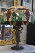 A large Art Nouveau style table lamp with stained glass shade.