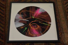A circular spin painting, framed and glazed.