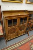 An oak bookcase with panelled and glazed door above two drawers.