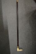 A bone handled walking stick, the handle modelled as a horse and jockey.
