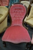 A Victorian walnut framed and button upholstered nursing chair.