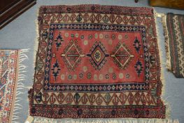 A Persian rug fragment, red ground with stylised decoration 113cm x 103cm.