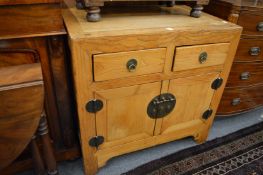 A Chinese light elm chest with two drawers and two cupboard doors.