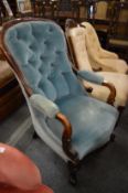 A Victorian mahogany framed and button upholstered open armchair.