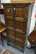 A Japanese dark wood standing cabinet with four pairs of panelled doors.