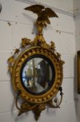 A Regency gilt framed convex wall mirror with pair of candle branches and eagle cresting.