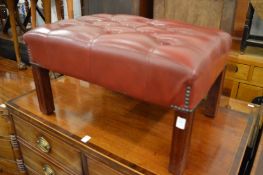 A good red button upholstered leather stool.