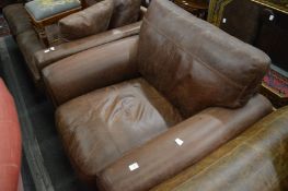 A brown leather upholstered armchair.