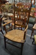 An Arts and Crafts style ash and rush seated spindle back armchair.