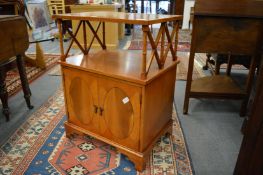 A yew wood two-tier occasional table with cupboard below.