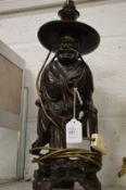 A Chinese carved wood figural table lamp.
