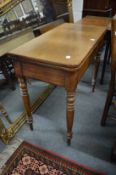 A 19th century mahogany fold-over tea table on turned legs.