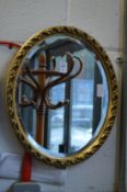 A small gilt framed oval mirror.