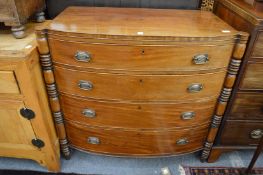 An early 19th century mahogany bow front four drawer chest with turned column supports.