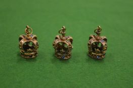 Three novelty pendants in the form of crowns.