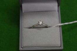 A platinum and diamond solitaire ring.