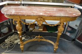 A marble topped carved and gilded console table.