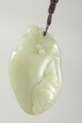 A CHINESE CARVED JADE PEBBLE PENDANT, 8cm x 5cm.