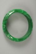A CARVED JADE BANGLE. 7cm diameter.