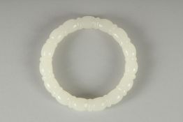 A CARVED TWIST WHITE JADE BANGLE. 8cm diameter.