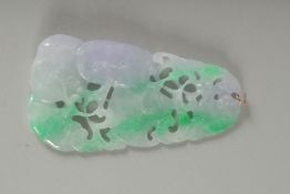 A LARGE CHINESE CARVED ICY JADE PENDANT with gold rings. 10cm x 5cm.