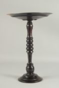 A LIGNUM VITA CIRCULAR CANDLE STAND 15ins high.