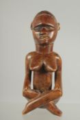 A SEATED TRIBAL FIGURE. 5.25ins high.