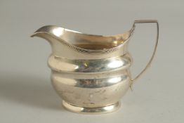 A GEORGE III SILVER MILK JUG with reeded edge and handle. London 1804. Maker: ANDREW FOGELBERG.