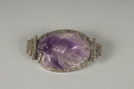 A CARVED AMETHYST BROOCH.