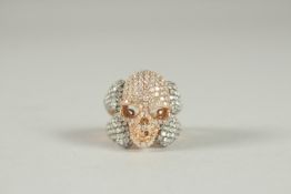 AN 18CT GOLD DIAMOND SET SKULL RING. 8.6gms.