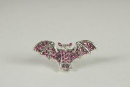 A SILVER RUBY, DIAMOND BAT BROOCH.