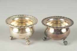 A PAIR OF CONTINENTAL SILVER CIRCULAR SALTS, on claw feet, stamped 800. 2.5ins diameter.