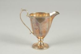 A SILVER PEDESTAL CREAM JUG. Birmingham 1930, 4ins high.