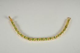 A SILVER , 18/CT GOLD PLATED, PERIDOT SET LINE BRACELET.