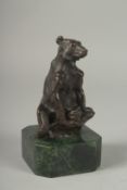 A SMALL BRONZE SEATED BEAR on a metal base. 5ins.