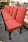 A set of eight Georgian style upholstered high back dining chairs on carved cabriole legs with pad