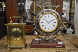 A mantel clock modelled as a ships wheel together with a modern brass carriage clock.